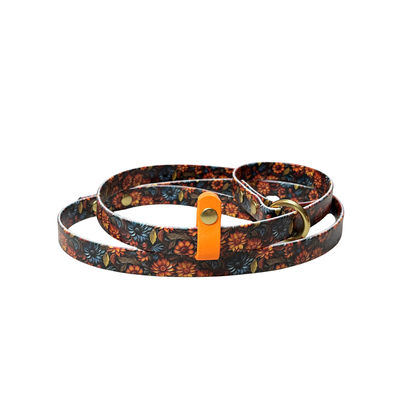 A coiled BioThane Slip Lead featuring a   carved-look floral pattern of orange, red, and blue flowers on a dark brown background, with a coordinating stop and brass O-ring and rivets.