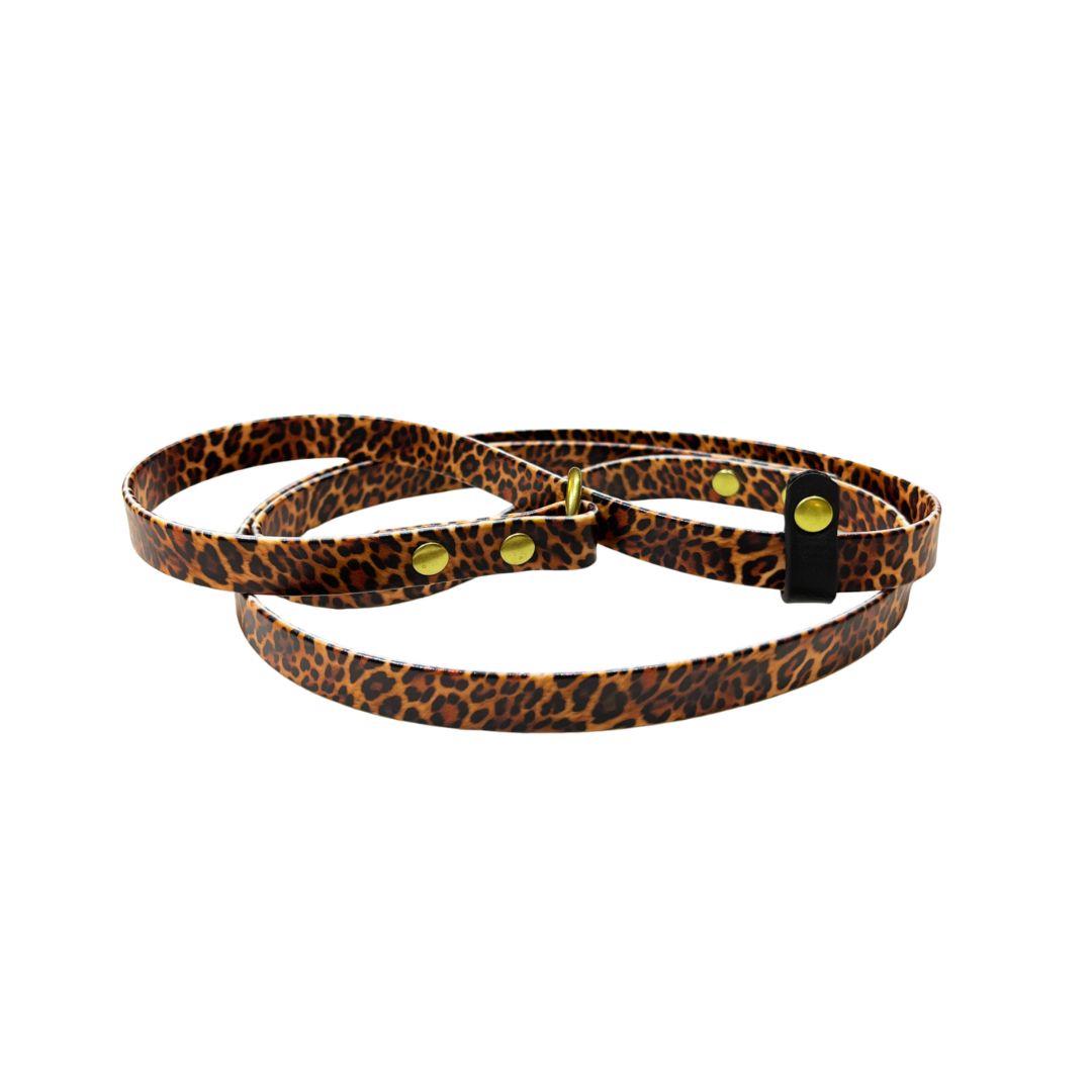 A leopard print BioThane Slip Lead with dark brown stop, and brass O-ring and rivets. Leopard print is tones of browns and black.